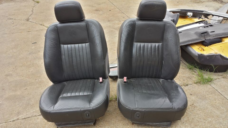 Two black leather car seats with headrests