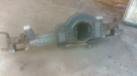 1978 Ford Bronco - A heavy-duty rear axle assembly, likely for a truck or SUV, is shown resting on a concrete surface. The assembly features a large different…