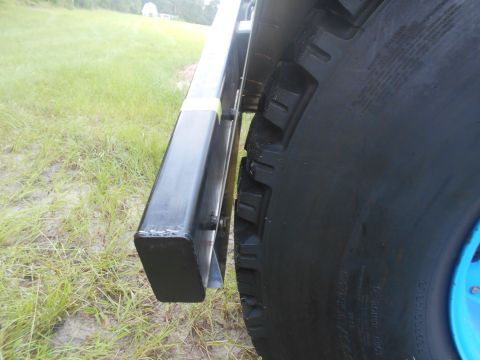1992 Ford Bronco - A close-up, side view of a large, black tire on a vehicle, with a black metal step or fender extension visible to the left. The vehicle app…