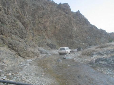 1981 Ford Bronco - Two SUVs navigate a rough, rocky terrain in a mountainous landscape.