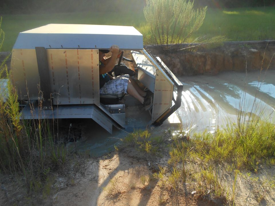 Custom metallic vehicle in mud with driver