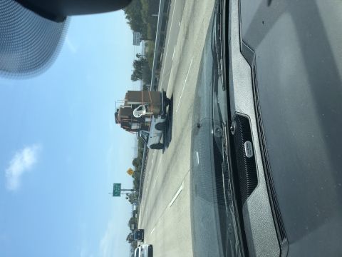 1992 Jeep Wrangler - A white pickup truck is heavily loaded with boxes and other items while driving on the highway.
