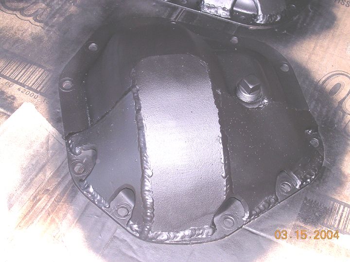 Freshly painted black differential cover with weld beads, dated 03.15.2004 in corner