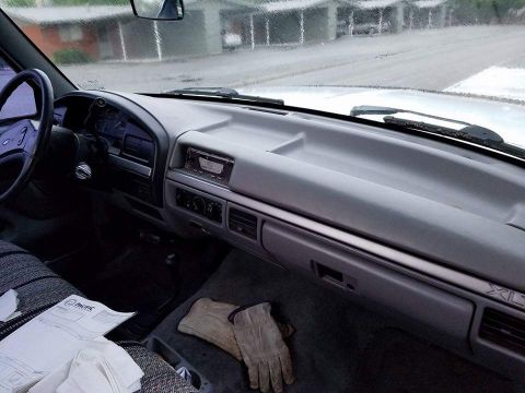 1995 Ford Bronco - The interior dashboard of a truck, showing the radio, glove compartment, and XL trim designation.