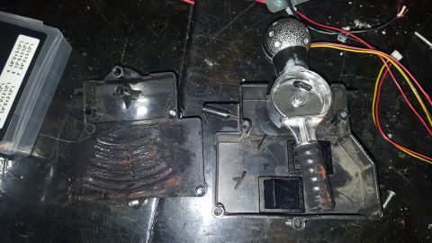 2007 Subaru Impreza - A disassembled car gear shifter assembly is shown with various wires and a small plastic container of parts.