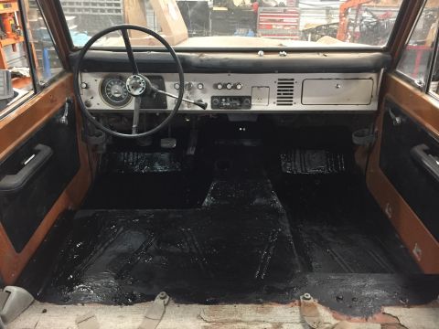 1969 Ford Bronco - The interior of a 1968 Ford Bronco shows a dashboard, steering wheel, and black floor mats.