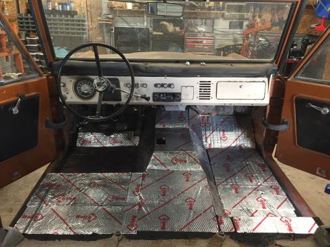 1969 Ford Bronco - The interior of a 1969 Ford Bronco is shown with sound deadening material being installed on the floor.