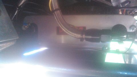 1992 Ford Bronco - Close-up of an engine component with a braided hose attached, showing a red label.