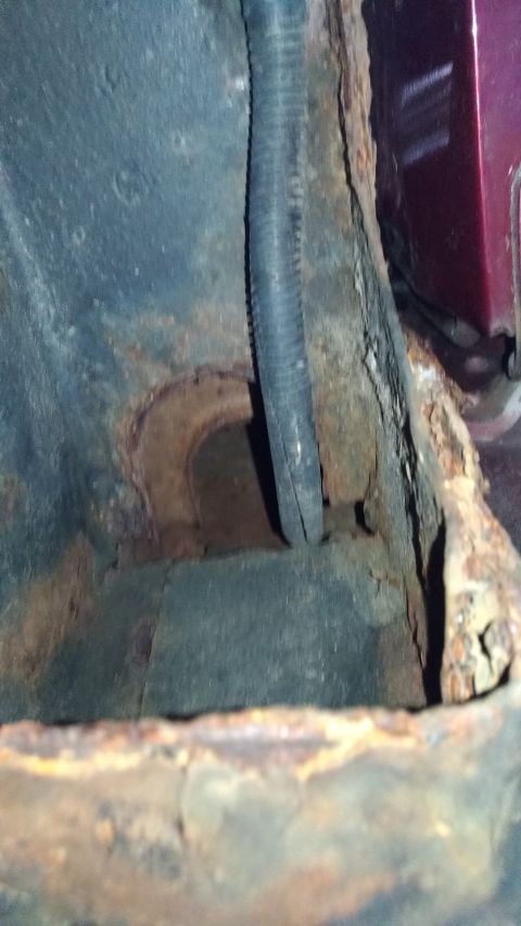 1996 Ford Bronco - Close-up of heavily rusted vehicle frame and a black wiring harness.