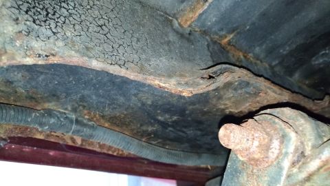 1996 Ford Bronco - The vehicle's undercarriage shows extensive rust and deterioration, indicating poor condition.