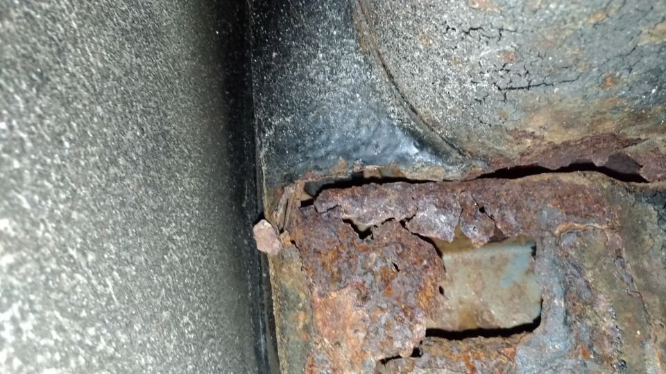 Heavily rusted frame rail with visible Supermotors.net watermark