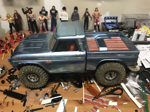 1989 Ford Bronco - A model pickup truck sits on a table with various parts and action figures scattered around it.