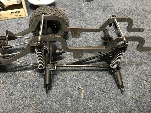 1989 Ford Bronco - RC car chassis assembly with suspension components and a partial tire.
