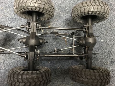 1989 Ford Bronco - Close-up view of the undercarriage and suspension system of a remote-controlled vehicle.
