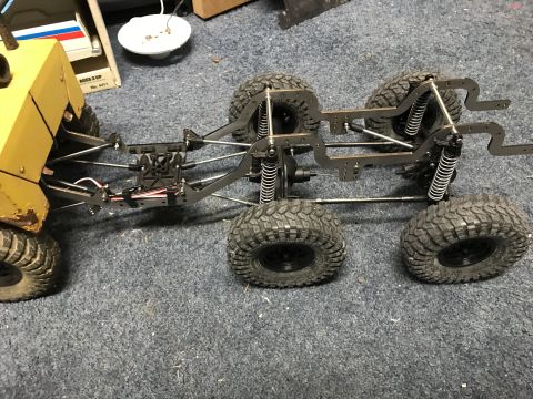 1989 Ford Bronco - This RC rock crawler chassis features a six-wheel drive system and a yellow body section.