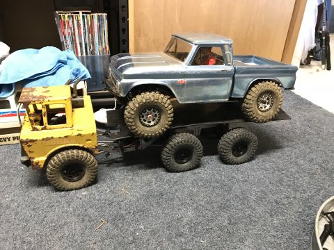 1989 Ford Bronco - A toy truck is loaded onto a toy trailer, which is carrying another toy truck.