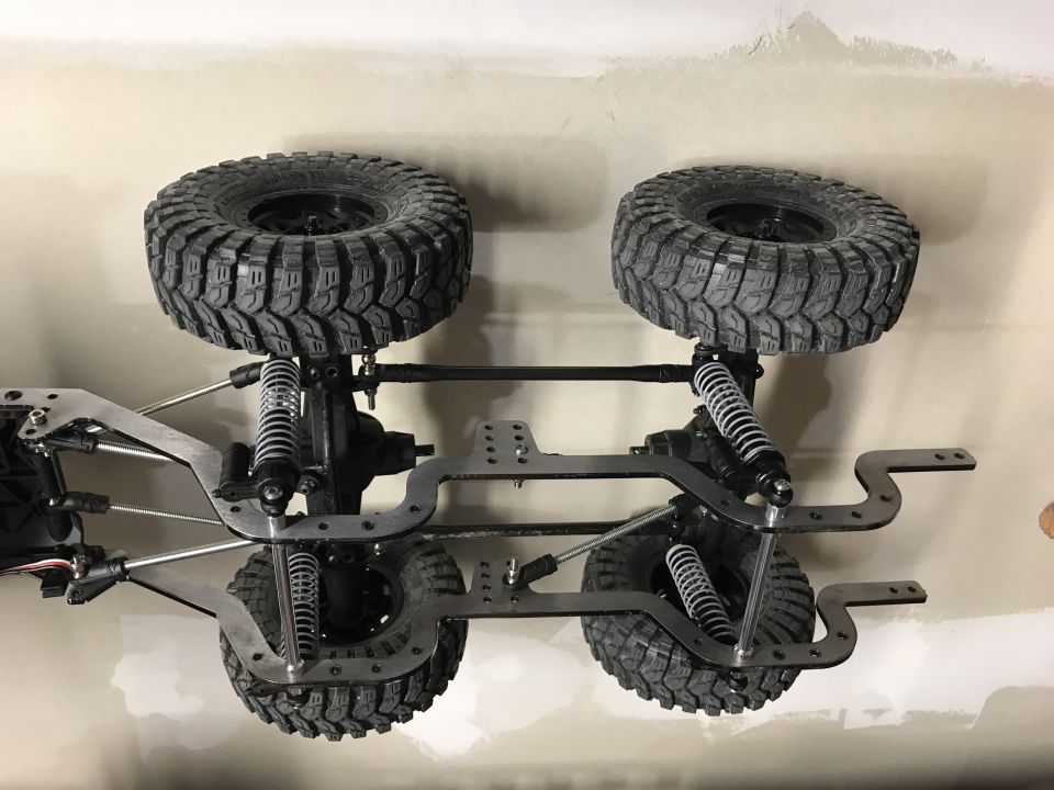 RC car chassis with four tires and suspension components