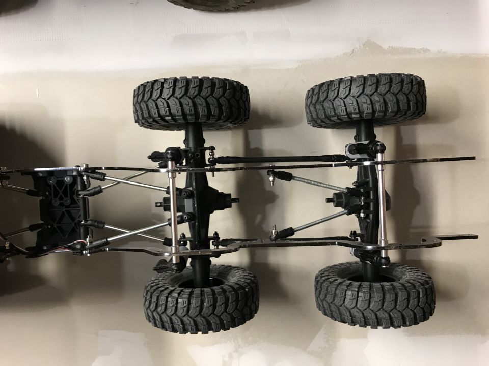 RC car chassis showing suspension, axles, and four tires