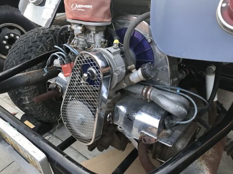 1970 Volkswagen Beetle - Close-up of a 1970 Volkswagen Beetle engine, showing its distinctive air-cooled design and chrome detailing.
