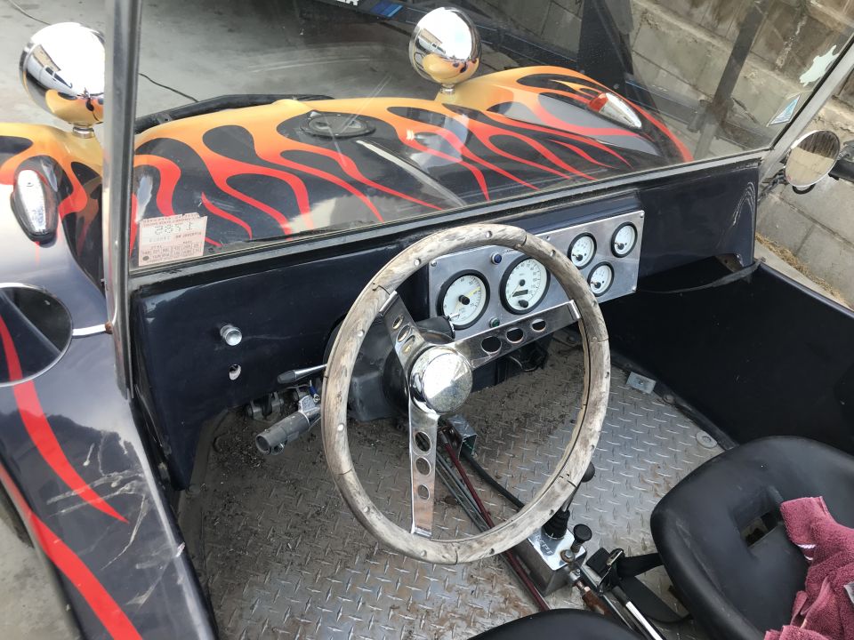 Hot rod interior with flame decals on dashboard and wooden steering wheel
