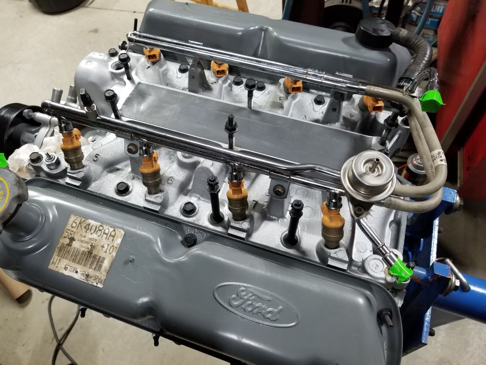 Ford V8 engine block with fuel injectors and fuel rails, part number sticker visible