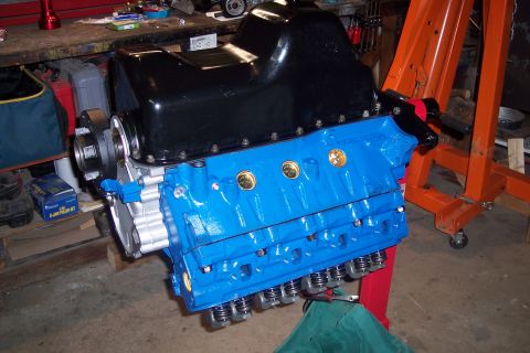1995 Ford Bronco - A freshly painted V8 engine is mounted on an engine hoist in a garage setting.