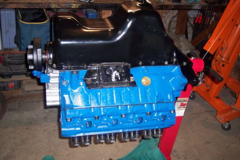 1995 Ford Bronco - Engine assembly on a stand, painted blue with a black oil pan. Text on a tag reads 'Heavy Duty'.