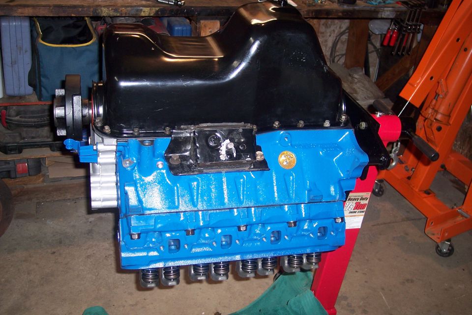 Blue engine block with black oil pan on an engine stand