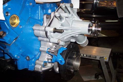1995 Ford Bronco - Close-up view of an engine water pump assembly, a blue engine block and silver pump components.