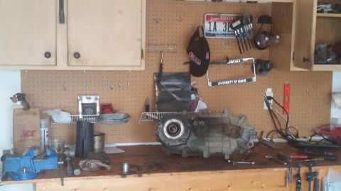 1985 Ford Bronco - Workbench with a transfer case, tools, and various items on the pegboard above.