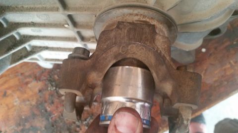 1985 Ford Bronco - A socket wrench is used on a rusty metal component, possibly part of a drivetrain, with "CC2" visible.