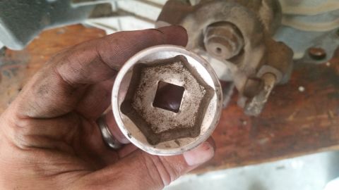 1985 Ford Bronco - Close-up of a socket wrench part being held by a hand.