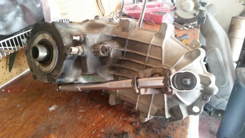 1985 Ford Bronco - A transmission assembly is shown on a wooden workbench with tools.