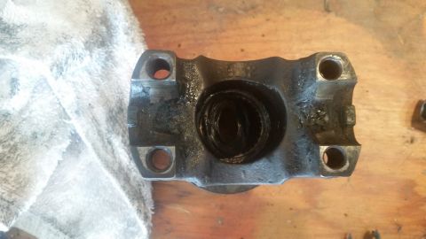 1985 Ford Bronco - A greasy driveshaft U-joint yoke is shown, likely removed for maintenance or repair.