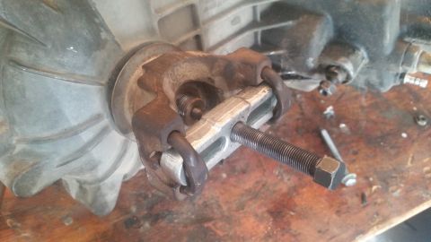 1985 Ford Bronco - A close-up view of a transmission component being worked on with a specialized tool.