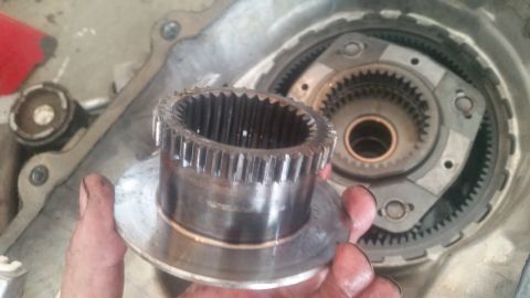 1985 Ford Bronco - A gear from a vehicle's transfer case is held up for inspection, revealing its internal teeth.