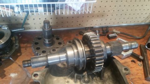 1985 Ford Bronco - Disassembled transmission components are laid out on a wooden surface, ready for inspection or repair.