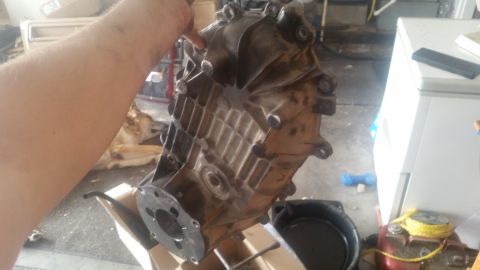 1985 Ford Bronco - Transfer case being held, with a dog lying down in the background.