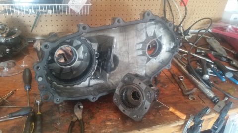 1985 Ford Bronco - Transfer case components laid out on a workbench, likely for repair or rebuild.