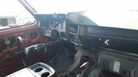 1981 Ford Bronco - The interior of a vehicle is shown with the dashboard disassembled, revealing the steering column and wiring.