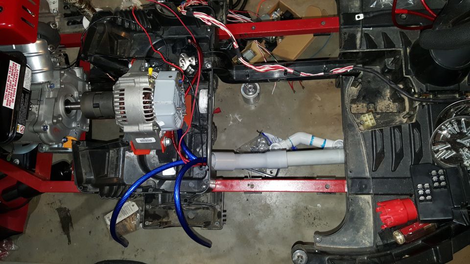 Generator and alternator assembly with wiring and plumbing components attached to a red frame
