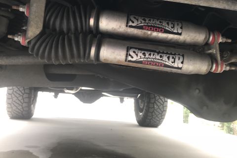 1995 Ford Bronco - Dual Skyjacker suspension shocks are visible on the underside of a vehicle's rear axle.