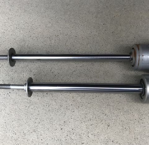 1995 Ford Bronco - Two shock absorbers are shown side-by-side on a concrete surface.