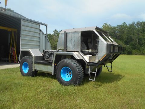 1992 Ford Bronco - This custom vehicle features a unique angular body and large off-road tires with bright blue rims.