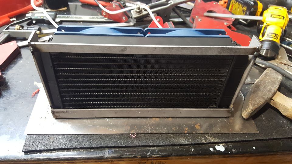 Custom radiator assembly with fans on a workbench.