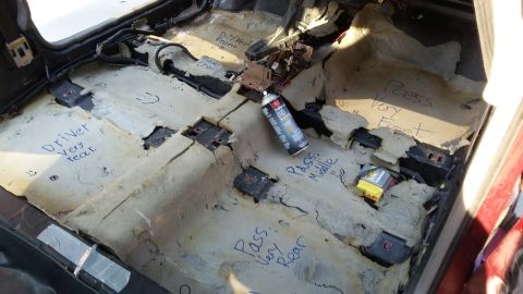 2000 Pontiac Grand Prix - The interior of a car with the carpet removed, revealing the floor pan and wiring. Handwritten labels mark different sections of the floor,…