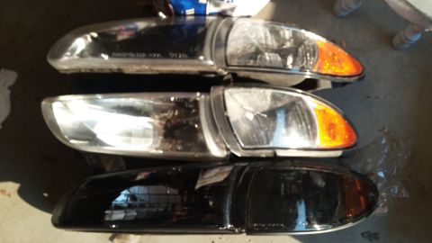 2000 Pontiac Grand Prix - Three car headlights are stacked vertically. The top two headlights appear to be clear with amber turn signals, while the bottom headlight…