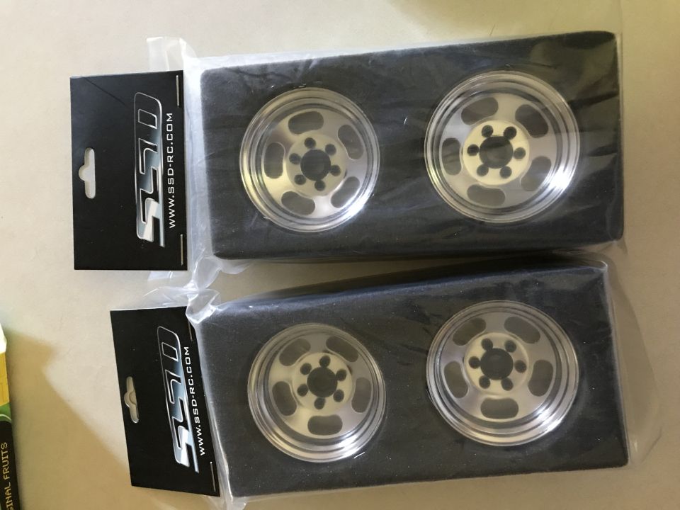 Two packages of four silver alloy wheels with black centers and SSD branding.