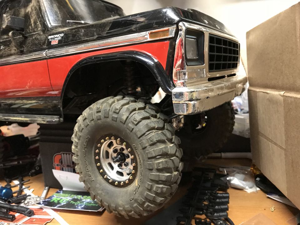 Black and red Ford Bronco XLT with large off-road tire and chrome bumper.