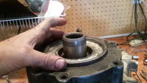1985 Ford Bronco - A person's dirty hand is holding a splined metal shaft that is inserted into a dark gray metal housing. The housing appears to be part of a…
